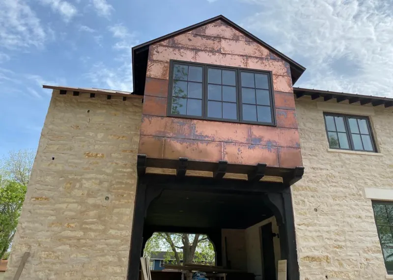 Copper metal panel facade on a stone building for Skylight Installation in Tupper Lake